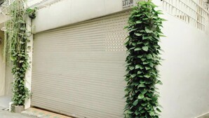 Puerta de garaje cerrada con un jardín vertical en la pared contigua.