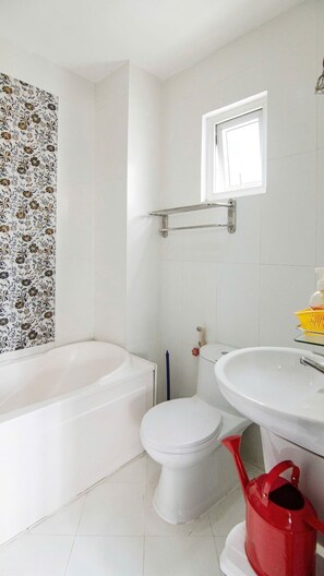 Un baño con bañera, inodoro y lavamanos.