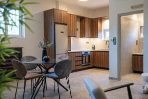 Una cocina moderna con armarios de madera, una mesa de comedor con sillas y un florero con flores.