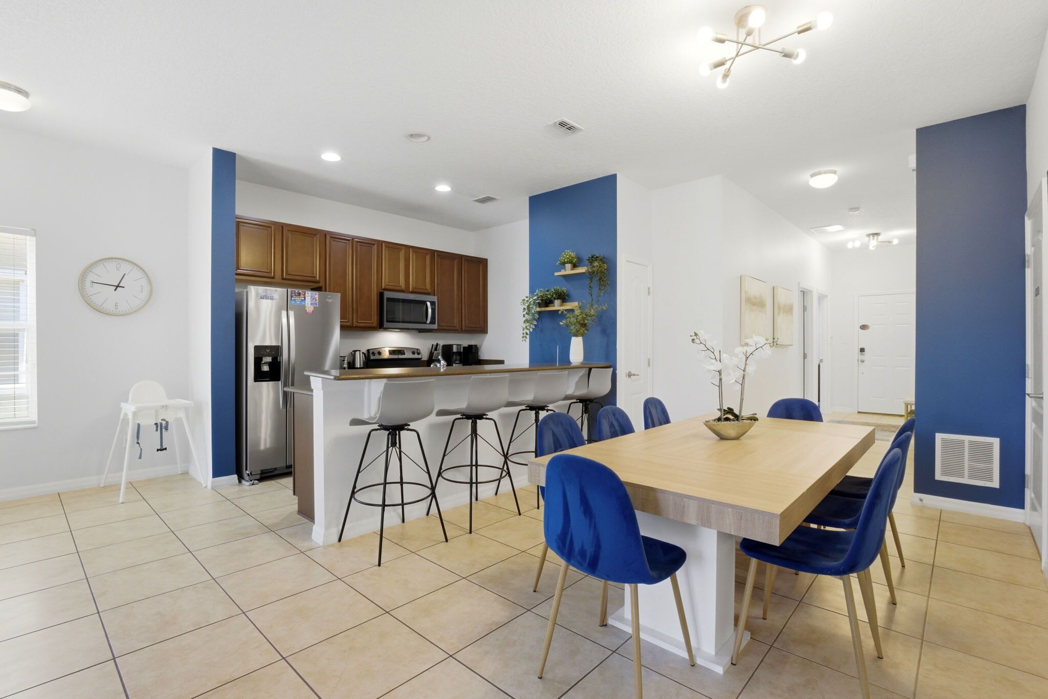 A modern kitchen with wooden cabinets, a stainless steel refrigerator, and a microwave.