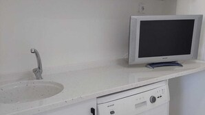 A kitchen with white cabinets, a sink, a dishwasher, and a microwave.