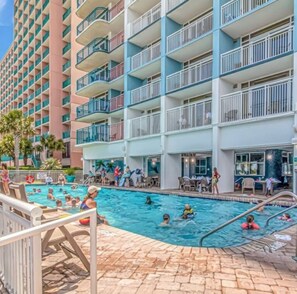 A hotel with multiple balconies, a swimming pool, and outdoor seating areas. - Premium Oceanfront Lookout, Newly Renovated, Immaculate, Direct Ocean View (Myrtle Beach)