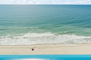 A beach with a clear view of the ocean, a sandy shore, and a few people. - Premium Oceanfront Lookout, Newly Renovated, Immaculate, Direct Ocean View (Myrtle Beach)