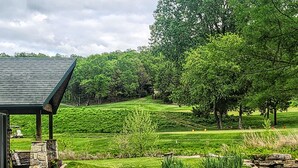 Un parcours de golf doté d’une structure en pierre et d’un étang.