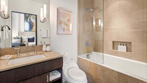 Une salle de bain moderne avec un grand miroir, un lavabo, des toilettes et une douche à parois de verre.