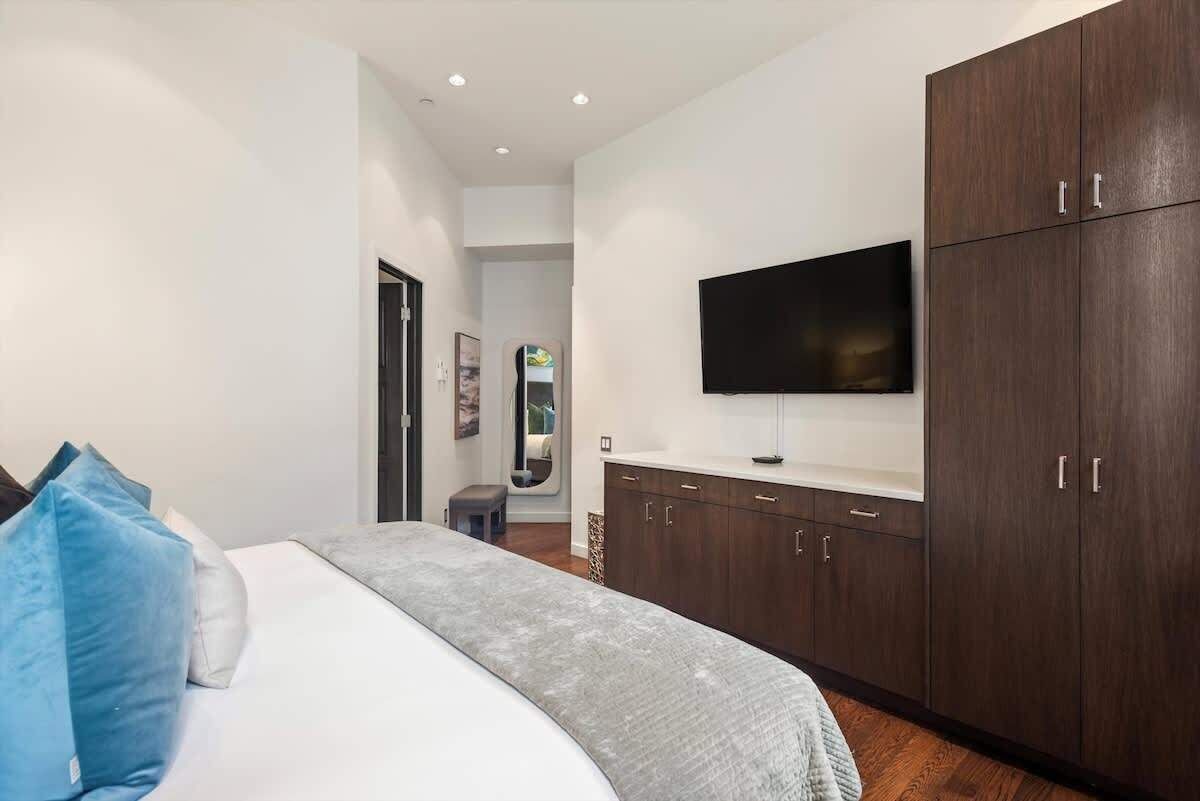 Una camera da letto con un letto, una TV a parete e un armadio.
