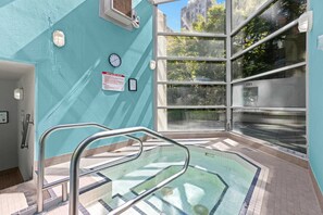 A pool area with a clear view of the outside, a clock, and a sign on the wall. - Stylish Downtown Condo with Free Parking + AC (Vancouver)
