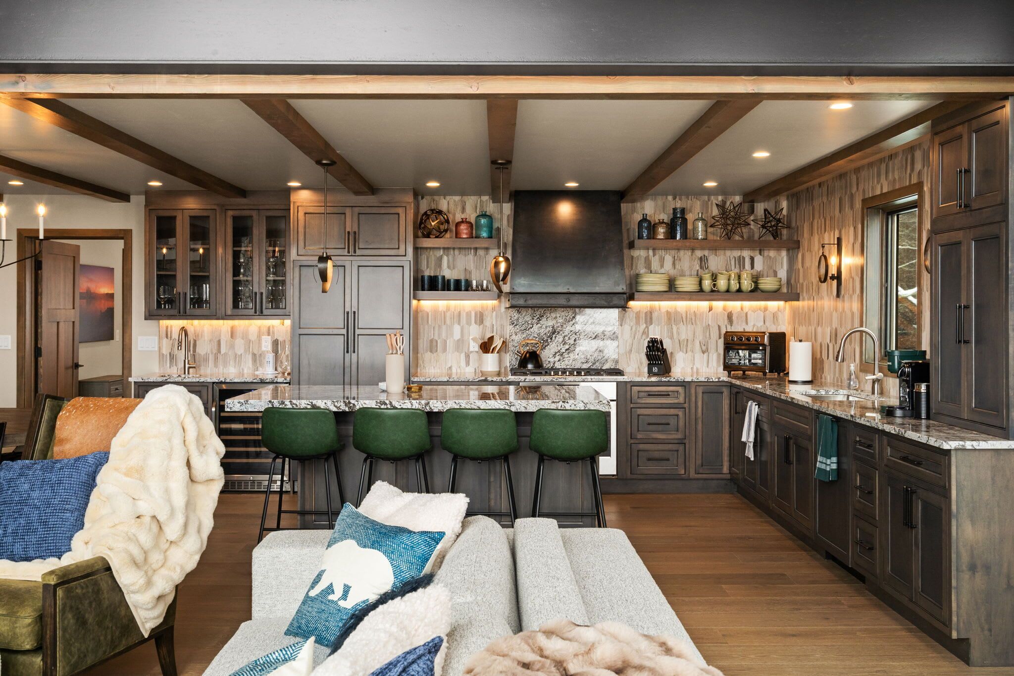 Une cuisine moderne avec des tabourets de bar, un grand îlot central et des meubles de rangement en bois.