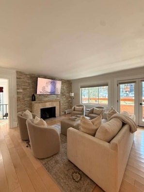 Una sala de estar con chimenea, un televisor de pantalla plana y un amplio ventanal con vistas.
