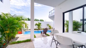 A modern outdoor patio with a pool, white furniture, and lush greenery. - Modern Villa w/ Pool & Garden, 1 Free Excursion (Punta Cana)