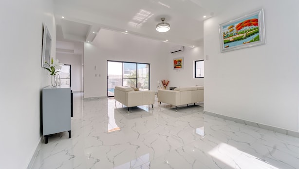 A modern interior with a marble floor, two sofas, a grey cabinet, and a painting on the wall. - Modern Villa w/ Pool & Garden, 1 Free Excursion (Punta Cana)