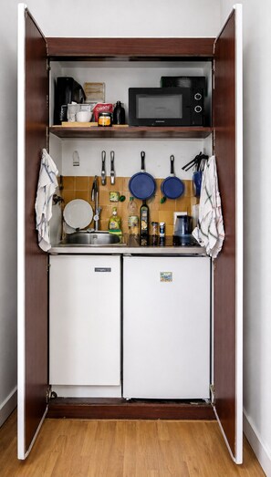 A compact kitchenette with a microwave, coffee maker, and a small refrigerator. - Parisian studio in the 17th district, fully equipped with balcony (Paris)