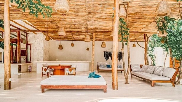 A spacious room with a wooden ceiling, a bed, a sofa, a dining table, and hanging lights. - Kasa Uh May (Francisco Uh May)