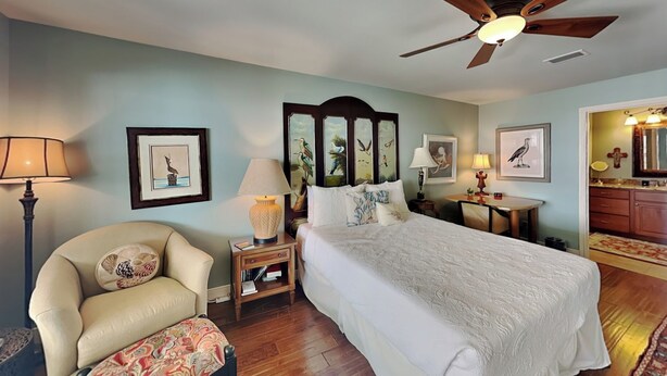 A bedroom with a bed, a chair, a desk, and a ceiling fan. - Galveston Baywatch (Galveston)