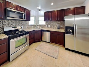 A kitchen with a stove, microwave, oven, dishwasher, and refrigerator. - Shell City (Galveston)