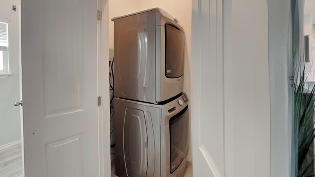 A compact kitchen with a built-in oven and microwave, a white door, and a wooden floor. - Pelican's Landing (Rockport)