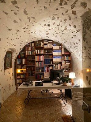 Une bibliothèque avec des étagères, un bureau et un ordinateur.