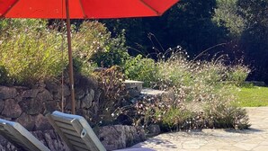A stone patio with two lounge chairs and a red umbrella. - 🌿 A Hidden Paradise Between Nice and Villefranche (Nice)