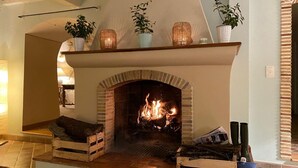 A fireplace with a brick arch, a mantel shelf with potted plants, and a wooden bench in front. - 🌿 A Hidden Paradise Between Nice and Villefranche (Nice)