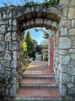 Un arc en pierre qui mène à un sentier bordé d’escaliers.