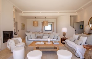 A spacious living room with a sofa set, a coffee table, and a fireplace. - 🌅 Cavalaire | Infinite Sea View & Infinity Pool (Cavalaire-sur-Mer)