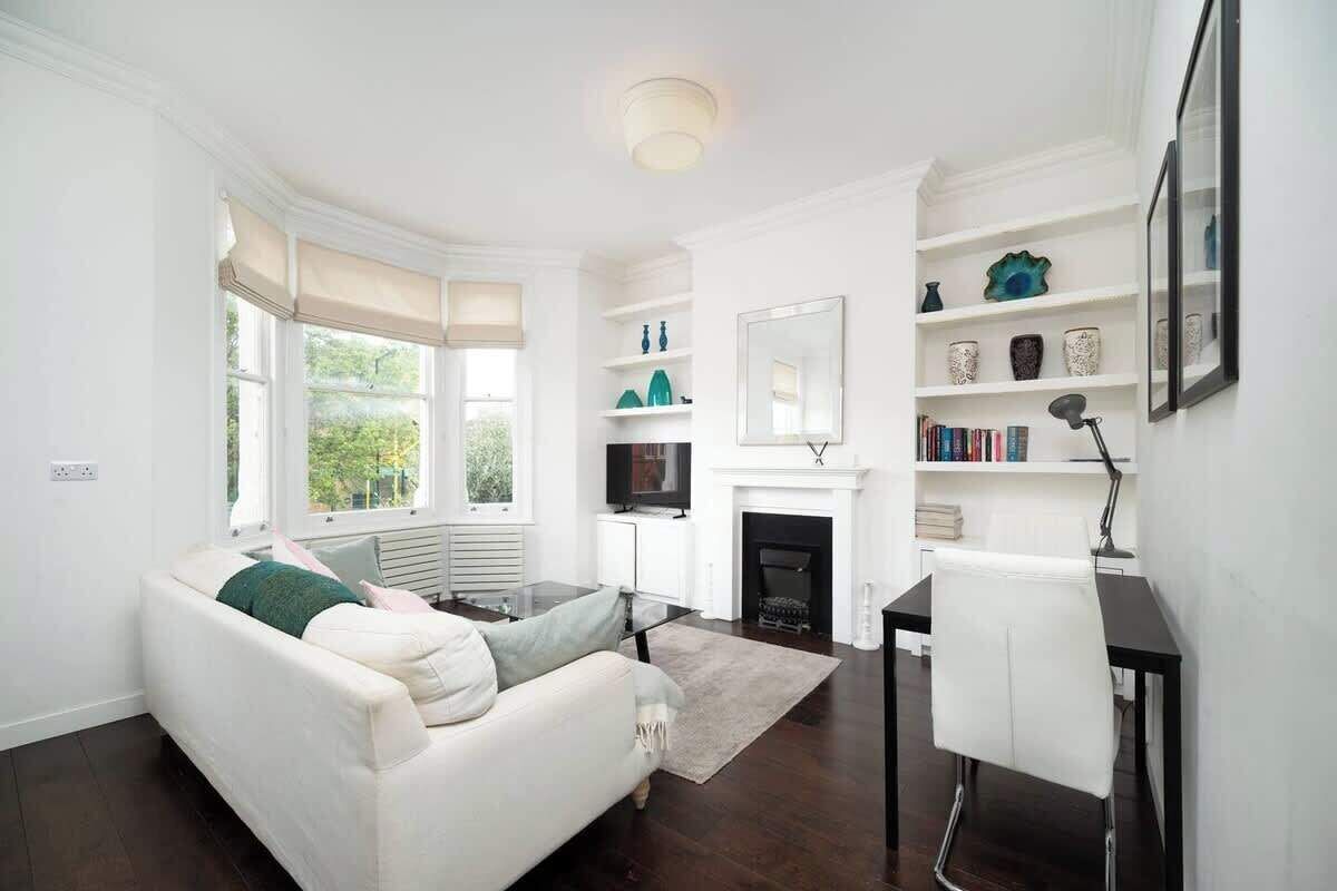 Ein modernes Wohnzimmer mit einem weißen Sofa, einem Kamin und einem Bücherregal.