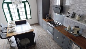 Une cuisine moderne avec un coin repas, comprenant une cuisinière à gaz, une machine à café et une grande fenêtre offrant une belle vue.