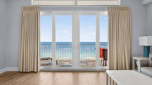 A room with a large sliding glass door leading to a balcony with a view of the sea. - Gulf View Resort Penthouse Condo! Beach & Pools (Panama City Beach)