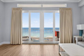 A room with a large sliding glass door leading to a balcony with a view of the sea. - Gulf View Resort Penthouse Condo! Beach & Pools (Panama City Beach)