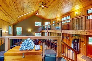 Interior de madeira em vários níveis, com área de jantar, bar e assentos.