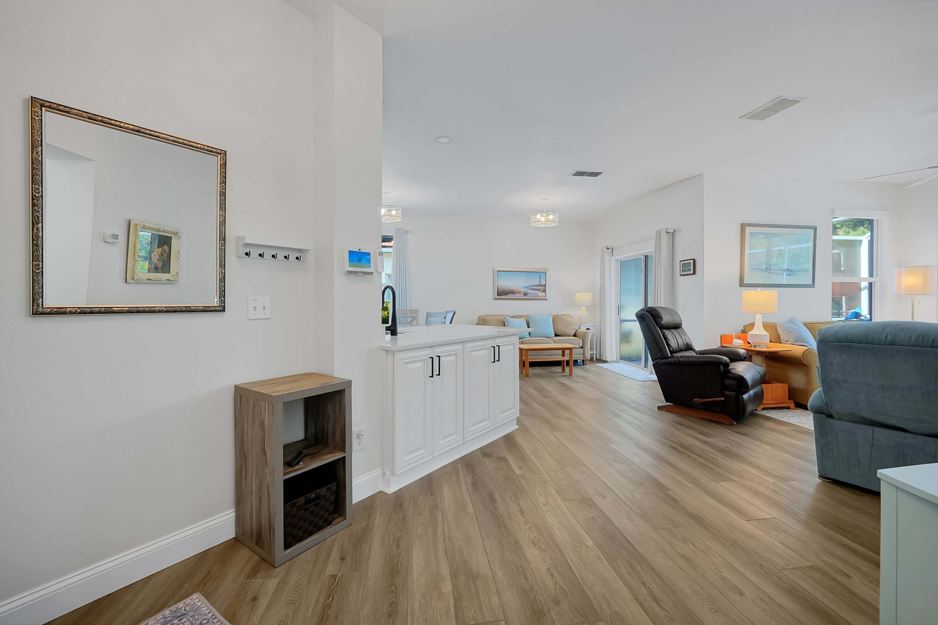A spacious living area with a kitchen, a dining area, and a seating area with a sofa and a recliner.