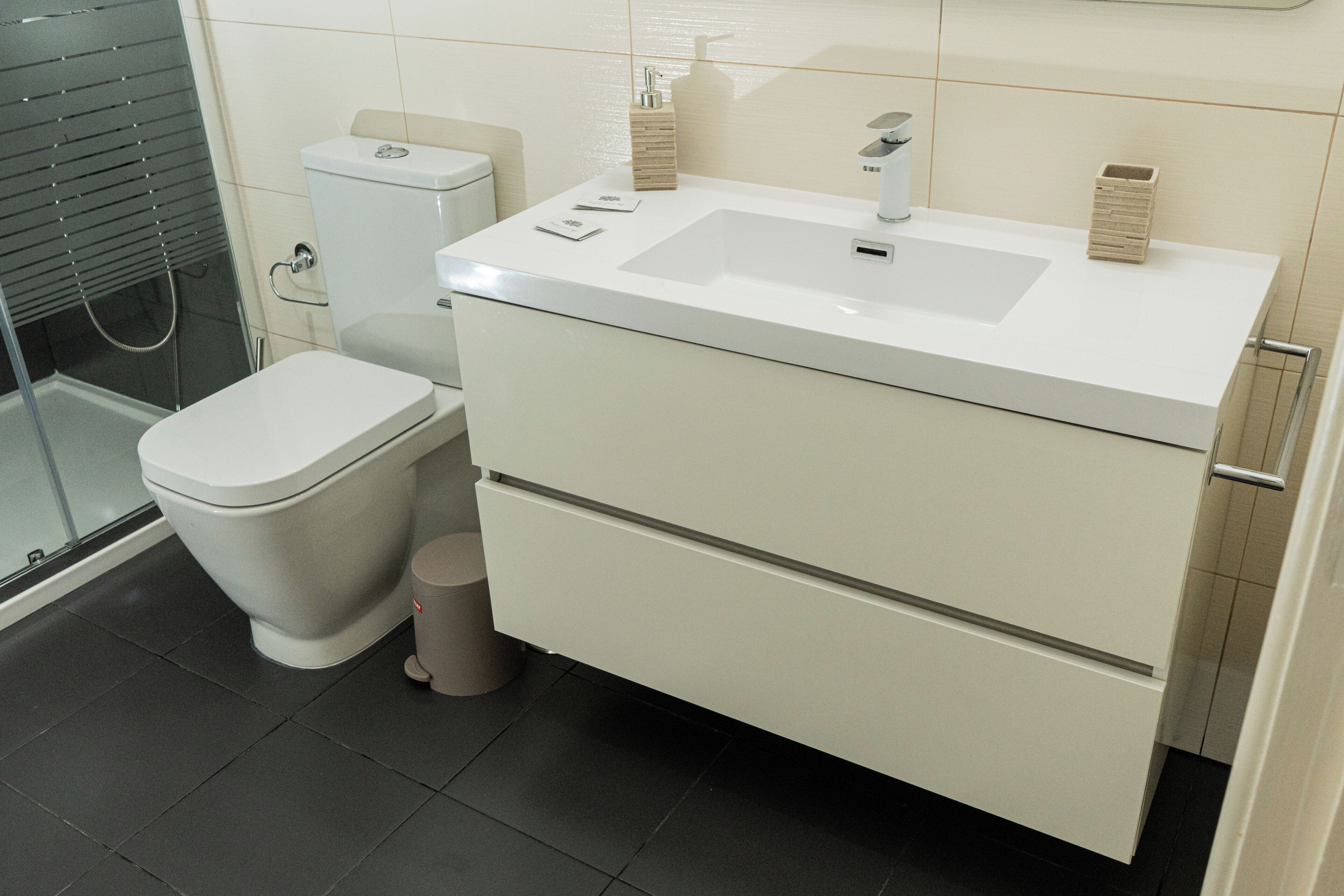 A bathroom with a toilet, sink, and shower.