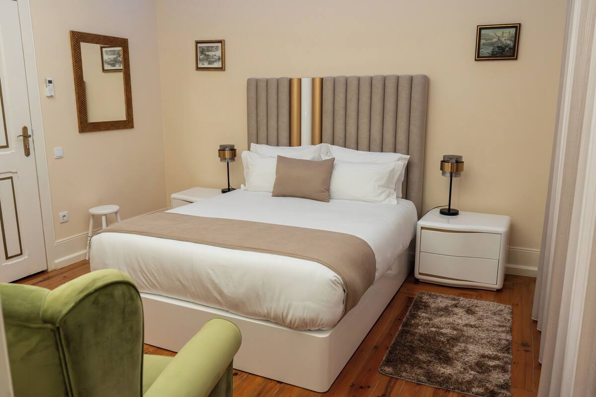 Une chambre à coucher bien aménagée, avec un grand lit, des tables de chevet, une chaise et un tapis.