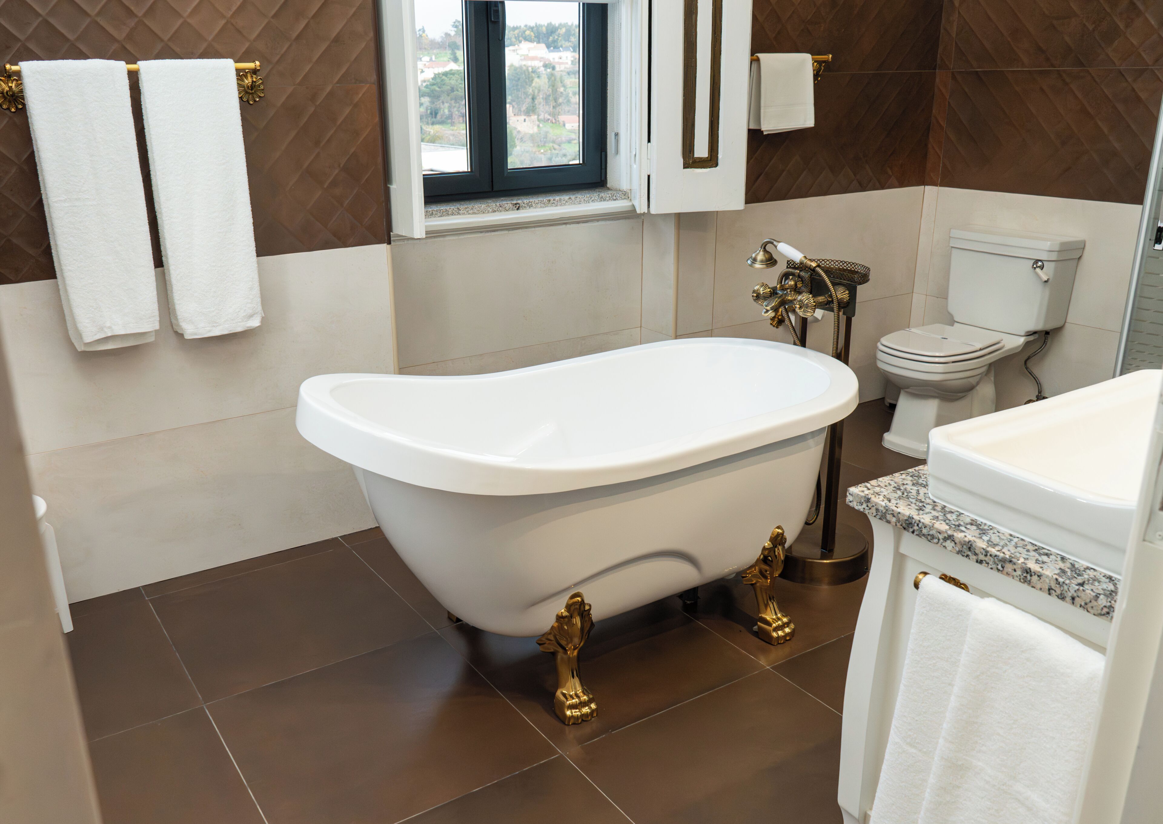 A bathroom with a freestanding bathtub, a toilet, and a sink.
