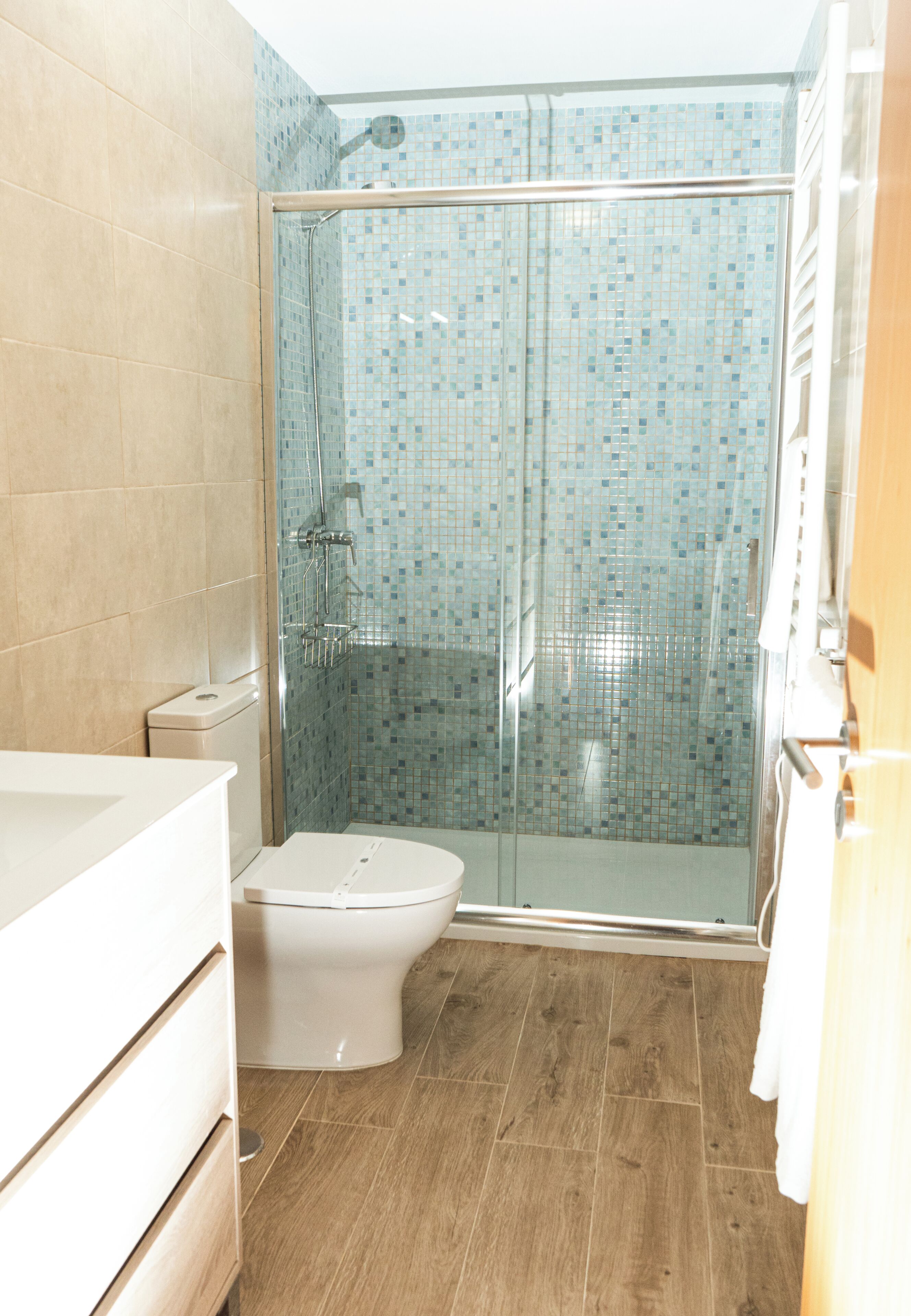 Un baño con ducha, inodoro y lavabo.