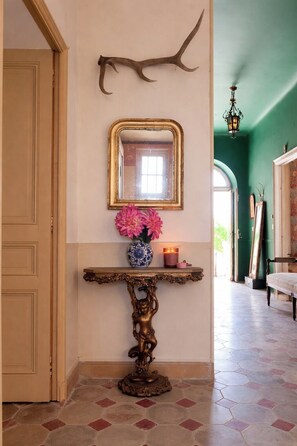A hallway with a decorative console table, a mirror, a vase with flowers, and a candle. - Maison de maître en Provence - Charming and old-fashioned in the countryside (Beaucaire)