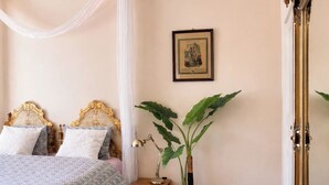 A bedroom with a canopy bed, a bedside table with a lamp, a potted plant, a large mirror, and a framed picture on the wall. - Maison de maître en Provence - Charming and old-fashioned in the countryside (Beaucaire)