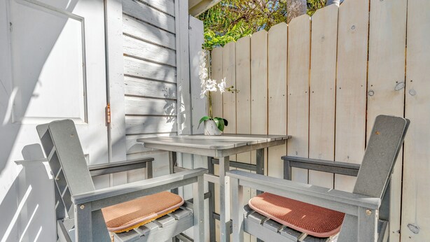 A patio with a table and two chairs, a potted plant, and a wooden fence. - Key West Steps to Duval, Truman Waterfront Park and Beach. Walk everywhere (Key West)