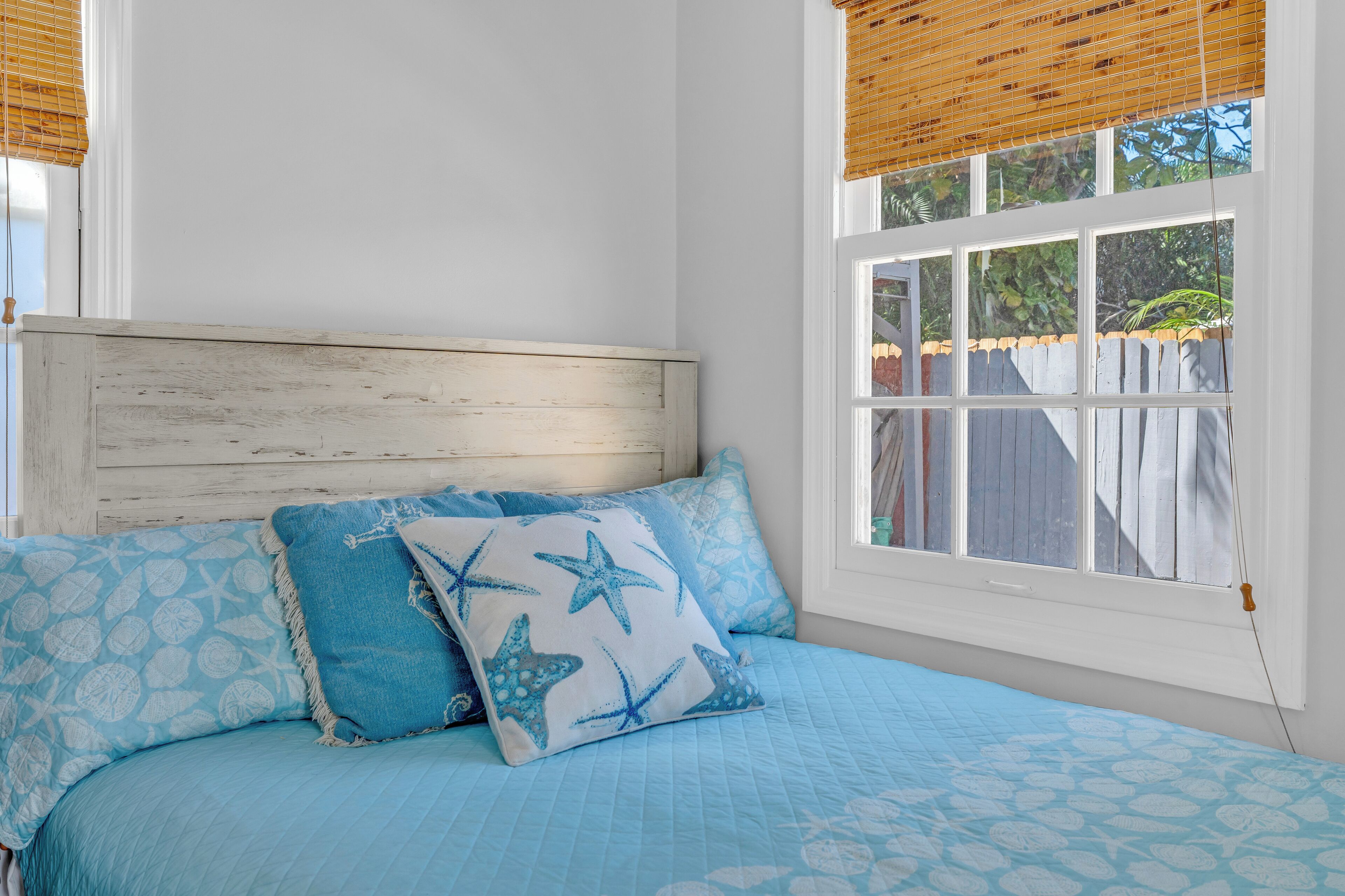Ein Schlafzimmer mit Bett, Kissen und einem Fenster.