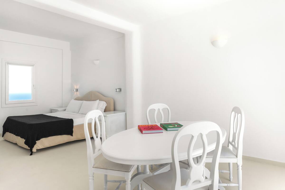 A bedroom with a bed, bedside table, and a window.