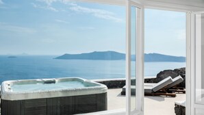A hot tub on a balcony with a view of the sea and mountains.