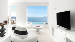 A modern living room with a large window, a flat-screen TV, and a white sofa.