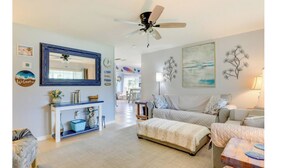 A spacious living room with a large mirror, a ceiling fan, and a sofa set. - Gulf Gate Getaway (Sarasota)