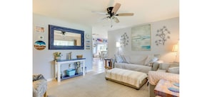 A spacious living room with a large mirror, a ceiling fan, and a sofa set. - Gulf Gate Getaway (Sarasota)