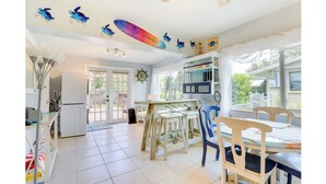 A kitchen with a dining area, a view of the outside, and a ceiling with decorative elements. - Gulf Gate Getaway (Sarasota)
