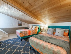 A bedroom with two beds, a wooden ceiling, and a patterned rug. - Boho Blue Heron, BBH 7532 (Birch Bay)