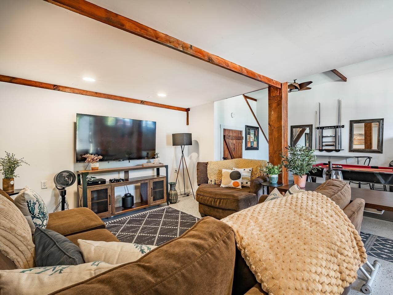 Ein Wohnzimmer mit Fernseher, Sofa und Billardtisch.