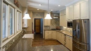 A kitchen with granite countertops, stainless steel appliances, and pendant lighting. - Spacious 4-bedroom estate in beautiful Spring Branch with AC and gym (Spring Branch)