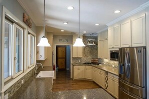 A kitchen with granite countertops, stainless steel appliances, and pendant lighting. - Spacious 4-bedroom estate in beautiful Spring Branch with AC and gym (Spring Branch)