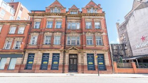 Edificio histórico con varios espacios de oficinas a la venta, amplias ventanas y un llamativo anuncio de Heineken.